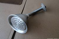 overall view of brushed nickel shower head attached to arm and flange