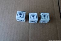 Front view of three Silver Cup billiard chalk cubes