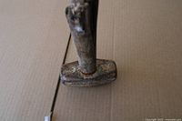 Top view of rusted sledgehammer head on cardboard surface