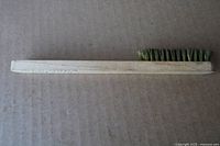 Full view of wooden wire brush showing handle length and bristle section