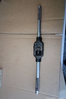 full view of steel tap wrench on cardboard background