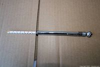 Overall view of metal tire gauge with scale extended