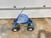 Side view of blue metal rolling garden seat cart with handle, basket, four wheels