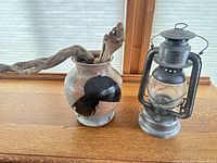Vase with driftwood next to Beacon lantern front angle