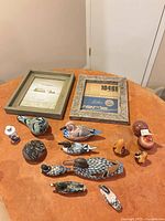 Top view showing all wooden bird figurines, pottery ornaments, decorative ball, cylinder vase and two picture frames