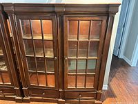 front view of hardwood glass-front display cabinet, doors closed