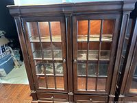 front view of cabinet showing glass-paneled double doors and drawers