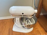 Left side view of mixer with bowl and attachments inside