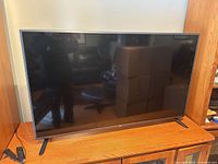 Front view of LG 55″ TV on cabinet with feet attached