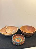 Three wood bowls and two serving utensils overview