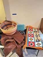 Basket, leather hide, rug, closed jewelry box on table