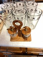Tall glasses and wooden salt & pepper mills on stand