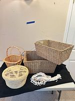 Group shot showing all five items together: two rectangular wicker baskets, round lidded basket, small handled basket, white macramé hanger