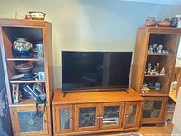 Full view of console centered between two bookcases, showing finish, glass doors and shelving