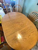 Top view of oval wooden dining table with four spindle-back chairs