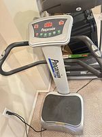 Front view of Progression vibration plate with control panel and handrails visible