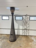 Brown wicker cone patio heater beside wrought iron lattice panel in garage