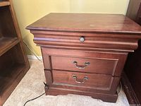Front view of one nightstand showing drawers and hardware