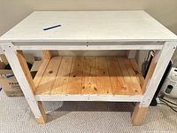 front view of solid wood workbench showing white top, natural pine shelf and legs