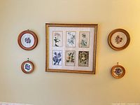 Full view of five framed artworks on wall