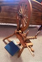 Side view of spinning wheel, blue book beside it