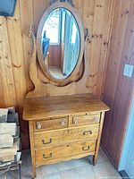 Front view showing entire dresser, drawers, and attached oval mirror
