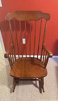 Front view of Windsor-style rocking chair showing full spindle back and seat