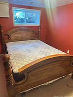 Full view of assembled queen bed showing wood headboard, footboard, mattress
