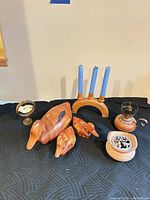 Group shot of all items: three wood ducks, wooden triple candle holder, metal candle holder, bird ornament on stand, wooden container