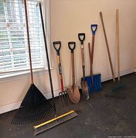 All eight yard tools leaning against wall