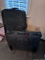 Front view of both luggage pieces showing size difference, exterior pockets, wheels, and handles