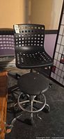 Front view of perforated plastic chair and padded stool