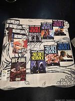 Full lot overview showing all eleven comic books laid out on fabric surface