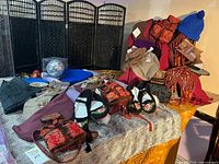 Overview of hats, scarves, embroidered bags on table