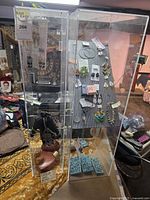 Full view of two plexiglass display cabinets with jewelry mounted on board inside