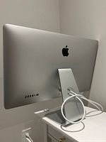 Rear view showing Apple logo, stand, coiled Thunderbolt cable