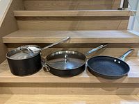 Group view of three pieces: saucepan with lid, sauté pan with lid, skillet