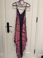 Full view of pink and navy tie-dye spaghetti-strap dress hanging