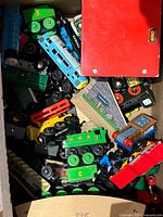 box filled with assorted Thomas & Friends wooden locomotives, cars and accessories
