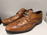 Left and right tan leather brogue shoes side view