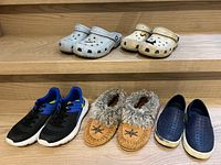 All five pairs of footwear displayed on wooden shelves