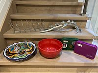 Group shot showing all items together on staircase: painted bowl, red bowl, two Yumbox boxes, wine rack, antler candelabra