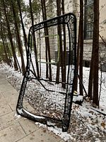 Front view of black folding lacrosse rebounder net showing mesh and target rectangle