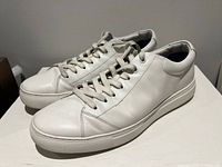 Left side view of white Hugo Boss sneakers showing leather uppers and laces