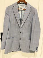 Full view of front of plaid sport jacket on hanger