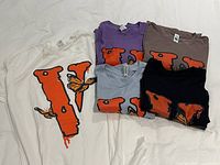 All five tees laid out showing colours and graphic