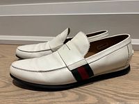 Side view of both white leather Gucci loafers with red-green stripe