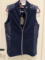 front view of navy blue KJUS vest showing full design and zipper