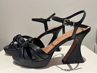 Side view of both shoes showing flared heels and ankle straps