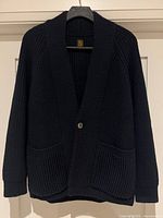 Full view of navy knit cardigan on hanger showing overall design and condition